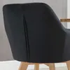 Close-up of the back of a black upholstered chair with wooden legs. Náhled obrázku produktu