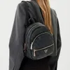 A person wearing a grey blazer and a black backpack with a logo pattern. Produktbild-Vorschau