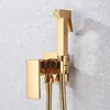 A gold bidet sprayer and holder mounted on a textured gray wall. Produktbild-Vorschau