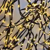 A close-up view of a string of LED lights with black wires and yellow lights. Produktbild-Vorschau