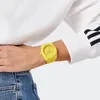 A person wearing a white sweatshirt with black stripes on the sleeve and blue jeans, wearing a yellow watch on their left wrist. Produktbild-Vorschau