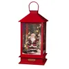 A red lantern with a Santa Claus figure inside, surrounded by Christmas trees and lights, with simulated snow. Produktbild-Vorschau