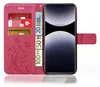 A pink flip phone case with floral embossing, showing credit cards and euro banknotes inserted into its compartments, and a smartphone placed inside. Produktbild-Vorschau