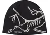 A black beanie with a white skeleton graphic and the Arc'teryx logo.