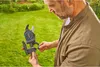 A man is holding and adjusting a pruning tool in a garden. Produktbild-Vorschau
