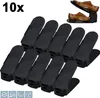A set of 10 black shoe organizers stacked and arranged on a white background. A pair of brown leather dress shoes is shown in the top right corner, demonstrating the organizer's use. Náhľad obrázku produktu