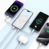 Multiple smartphones and a pair of wireless earbuds are connected to a white power bank, suggesting charging. Náhled obrázku produktu