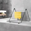 A black metal drying rack with a yellow towel draped over it, placed on the edge of a bathtub in a modern bathroom. Voir les images du produit