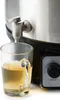 A close-up of a beverage dispenser with a glass of amber liquid being filled. Podgląd zdjęcia produktu