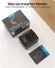 A black universal travel adapter and its packaging are displayed on a white surface with a wooden background element. Náhled obrázku produktu