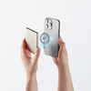 Hands holding a smartphone and a power bank, demonstrating magnetic wireless charging. Voir les images du produit