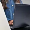 A person wearing a denim jacket is using a MacBook Pro with an Incase Edge case. Produktbild-Vorschau