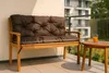A brown cushion on a wooden bench on a balcony with a glass railing and a small table with a glass of orange juice. Produktbild-Vorschau
