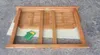A wooden table is shown from the underside, resting on a concrete surface. Produktbild-Vorschau