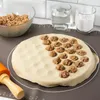 A close-up shot of dough being prepared for making ravioli, with filling and ingredients visible. Náhled obrázku produktu