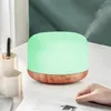 An aroma diffuser with a green light is shown on a desk with a hand reaching towards it. Anteprima dell’immagine prodotto