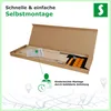 An opened cardboard box containing parts of a slatted bed base, along with assembly instructions and hardware. Produktbild-Vorschau