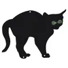 A silhouette of a black cat with green eyes against a white background. Voir les images du produit