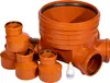 A set of orange plastic sewage pipes and fittings, including a large base, several smaller pipes, and a small bottle of lubricant, arranged on a white background. Produktbild-Vorschau