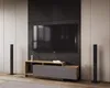 A modern entertainment center with a TV mounted on a textured wall panel, a media console below, and two tall speakers on either side. Náhled obrázku produktu