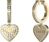 A pair of gold heart-shaped earrings with clear stones and the brand name 'Guess' inscribed on them. Podgląd zdjęcia produktu