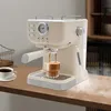An espresso machine is making coffee on a wooden counter, with a cup of coffee and a wire basket in the background. Náhled obrázku produktu