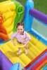 A young girl is playing on a colorful inflatable trampoline. Voir les images du produit