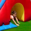 A young girl is crawling out of an inflatable play structure. Náhled obrázku produktu