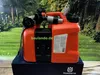 An orange Husqvarna kombikanister with a black compartment, set against a blurred background of trees and grass. Voir les images du produit