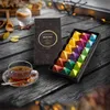 A tea set with a box of tea and a cup of tea on a wooden table. Produktbild-Vorschau