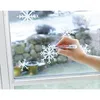 A hand is using a white marker to draw a snowflake on a window, with other snowflakes already drawn on the glass. Anteprima dell’immagine prodotto