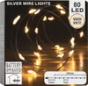 The image shows the packaging of silver wire lights with warm white LEDs. Voir les images du produit