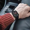 A person wearing a red sweater and a black Apple Watch with a protective case, sitting in a car. Produktbild-Vorschau