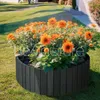 A circular wooden planter filled with bright orange flowers sits on a green lawn. Náhled obrázku produktu