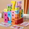 A stack of colorful wooden number blocks arranged in a tower, with three small cards showing number patterns in front of the blocks. Produktbild-Vorschau
