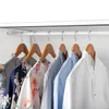 Several shirts hanging on wooden hangers on a white closet rod. Náhľad obrázku produktu