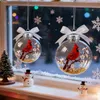 Christmas ornaments hanging in a window with a snowy scene outside. Produktbild-Vorschau