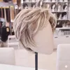 Kurze, geschichtete blonde Perücke auf einem Schaufensterkopf, von der Seite in einem Salon gesehen Voir les images du produit