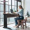A woman is working on a laptop at a standing desk next to a large window. Anteprima dell’immagine prodotto