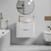 A modern bathroom with a white vanity, sink, faucet, bathtub, and toilet. A cat is sitting on the toilet. Produktbild-Vorschau