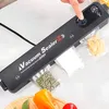 A vacuum sealer is shown sealing bags of food, with fresh produce in the foreground. Produktbild-Vorschau