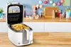 A kitchen counter with a deep fryer filled with french fries, and various kitchen items in the background. Produktbild-Vorschau