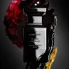 A Tom Ford Black Lacquer Eau de Parfum bottle is presented with artistic elements like a red rose and dark, glossy liquid. Produktbild-Vorschau
