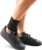 A person's legs wearing a black ankle brace and black sneakers against a white background. Produktbild-Vorschau