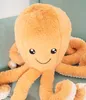 A close-up of a plush octopus toy sitting on a light green chair. Anteprima dell’immagine prodotto
