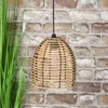 A rattan-look pendant lamp hangs in front of a brick wall, with green grass to the left. Anteprima dell’immagine prodotto