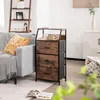A living room scene with a grey sofa, a wooden and black storage unit with three drawers, and a ladder shelf in the background. Náhled obrázku produktu