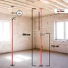 Two adjustable ceiling support poles are shown in an unfinished room with concrete block walls and a wooden ceiling. Produktbild-Vorschau