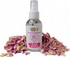 A bottle of rose water is surrounded by dried rose petals. Podgląd zdjęcia produktu