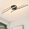 A modern LED ceiling light with a curved design, mounted on a white ceiling. Voir les images du produit